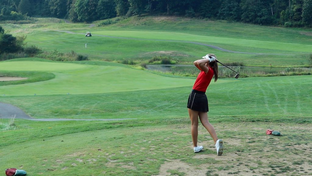 New Philadelphia senior Sydney Devore tees off on the fifth hole of Oak Shadows' back nine in the Quakers' match against Fairless High School on Monday, September 13, 2021.