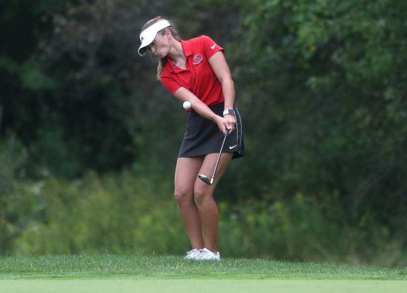 Sydney Devore of New Philadelphia’s girls golf team chips on to the first green at Oak Shadows Golf Club Wednesday in the match with Canton Central Catholic and Warren. (JMN Sports/ Jim Cummings)