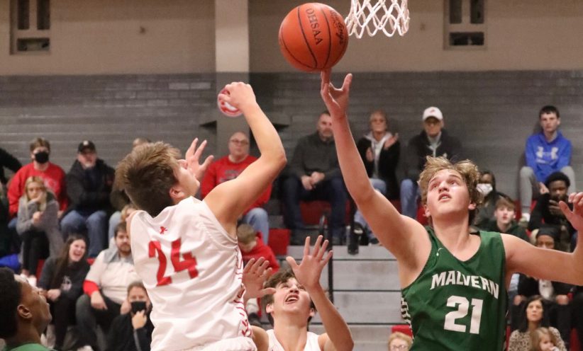 Malvern's Michael Minor (right, green) goes for the ball against Minerva's Brayden Costea (left, white) during the Hornets' 63-43 win on Tuesday night at Minerva High School.