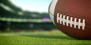 american-football-ball-on-grass-of-football-arena-M2THXJQ-scaled